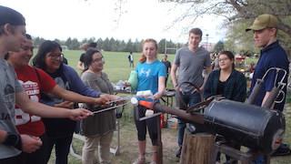 An image of students making smores around an experiment.